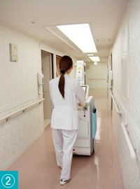 (2) 病棟の廊下を病室まで移動中。電動アシスト機能を搭載したMobilett Miraは，力を使うことなくスムーズに移動できる。